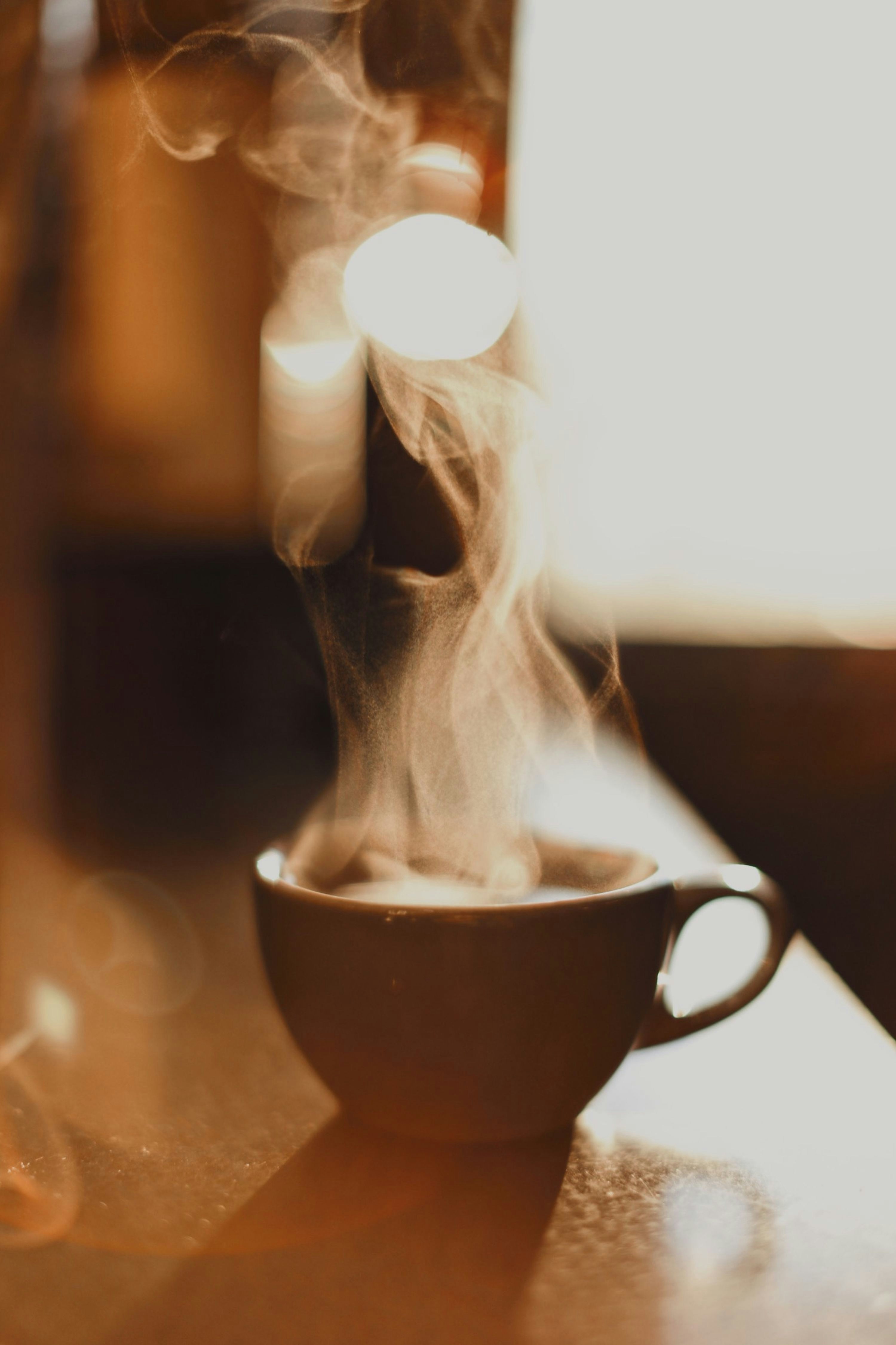 A steaming cup of coffee in warm morning light